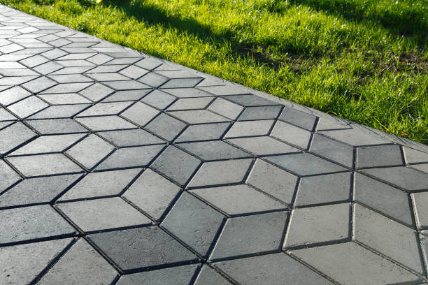 the footpath in the park is paved with diamond shaped concrete tiles.